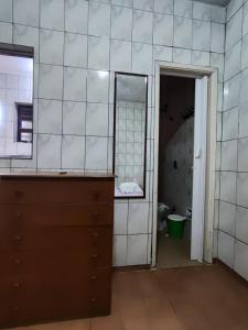 an empty bathroom with a mirror and a dresser at cantinho aconchegante in Praia Grande