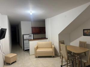 a living room with a table and chairs and a kitchen at Un lugar cómodo y acogedor in Barranquilla