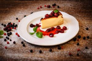 a piece of cake on a white plate with berries at Jakubowa Izba in Niwa Babicka