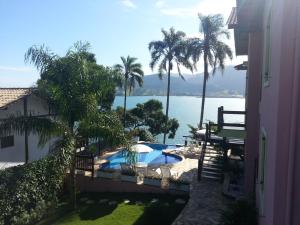 uitzicht op een zwembad en het water bij Pousada Fruto do Mar in Ilhabela