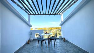 a patio with a table and chairs on a balcony at Zephyr House 3BR Pool, Rooftop & Ocean View in Grand Gaube