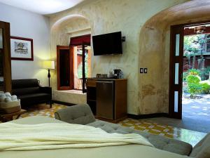 a bedroom with a bed and a tv on the wall at Hotel Siglo 17 in Oaxaca City