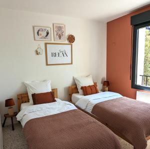 a bedroom with two beds and a window at Gîte Le Petit rien du Bas in Balazuc