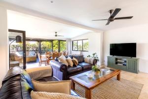 Una sala de estar con un sofá y un televisor. en Franschhoek Charm, en Franschhoek
