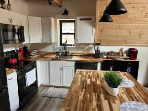 une cuisine avec des armoires blanches et une table en bois dans l'établissement Baby Chocorua, à Tamworth