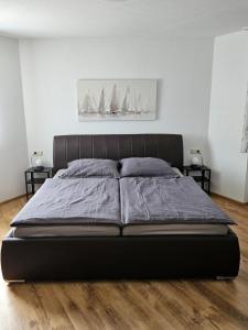 a large bed in a bedroom with two tables at Ferienwohnung am Bodensee in Tettnang