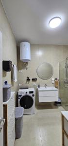 a bathroom with a sink and a toilet and a tub at Agel Apartment in Tirana +5 photos