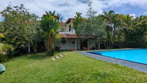 a villa with a swimming pool and a house at Zen Bentota Ayurveda Resort in Bentota
