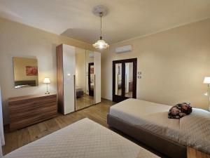 a bedroom with two beds and a large mirror at Buildings & Grounds - casa ugo F in Pisa