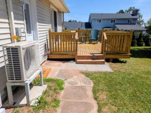 Un patio trasero con aire acondicionado en una terraza. en The Convenient Suite, en Charlottetown