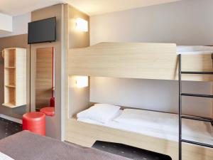 a room with bunk beds with a flat screen tv at B&B Hotel Saarbrücken-Hbf in Saarbrücken