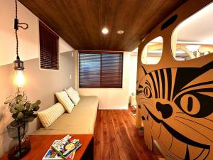 een woonkamer met een schilderij van een kat aan de muur bij Le Cave Troll ル カーブ トロル in Mitaka