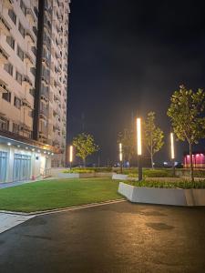 a night view of a park with trees and buildings at Stylish 1bedroom apartment at Muntinlupa in Manila