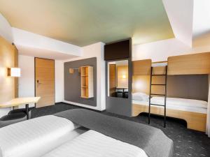 a bedroom with two bunk beds and a desk at B&B HOTEL Wien-St-Marx in Vienna