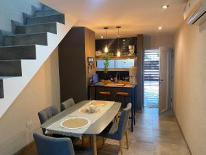 a dining room and kitchen with a table and chairs at Las Amelias Apart in Ezeiza