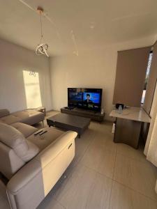 ein Wohnzimmer mit Couch und Flachbildfernseher in der Unterkunft La Villa d'Élixira - Grand Baie, Mauritius in Grand Baie