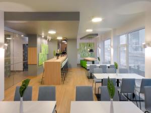 a restaurant with tables and chairs and a bar at B&B Hotel Paderborn in Paderborn