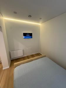 Un dormitorio con una cama y un televisor en la pared. en 13 New Airport Apartment, en VNO