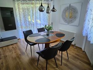 a dining room with a wooden table and chairs at Ferienwohnung am Bodensee in Tettnang