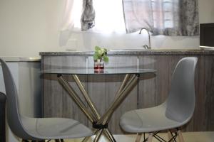 a glass table with two white chairs and a sink at Newlands Comfortable Abode in Johannesburg +52 photos