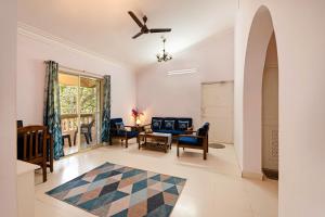 ein Wohnzimmer mit einem blauen Sofa und Stühlen in der Unterkunft Saurina's Beach Retreat near Candolim Beach in Goa