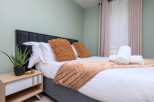 a bedroom with two beds with pillows and a plant at Gautrain Classy Apartment in Midrand