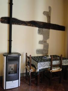 a room with a fireplace and a table and a stove at La Guardia B&B in Stia