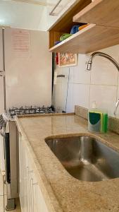 a kitchen with a sink and a stove at Casa completa com 2 quartos, Perto de tudo in Cabo Frio