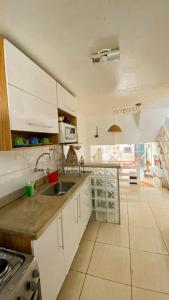 a kitchen with white cabinets and a sink at Casa completa com 2 quartos, Perto de tudo in Cabo Frio