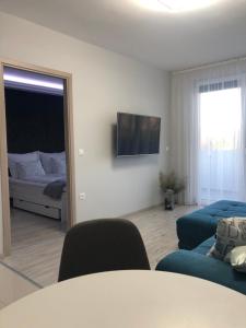 - un salon avec une table, un canapé et un lit dans l'établissement Luca Apartman, à Keszthely