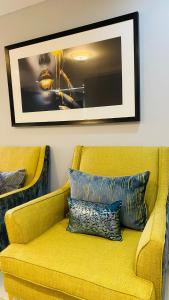 a yellow couch in a living room with a picture on the wall at Home away from Home in Maseru
