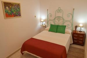 une chambre avec un grand lit avec des oreillers verts dans l'établissement Casa Rural KIN & FUL, à Cala