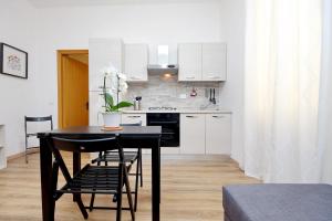 a kitchen with a black table and chairs in a room at Holiday rental San Lorenzo district in Rome