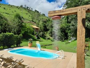 una piscina en un patio con una cascada en Chale Nossa Senhora Aparecida, en Cunha