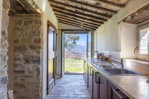 a kitchen with a sink and a stone wall at La Capella in Gubbio