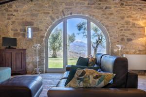 a living room with a couch and a large window at La Capella in Gubbio