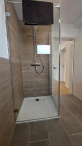 a shower with a glass door in a bathroom at Fewo Gerda im schönen Odw in Mörlenbach +41 photos