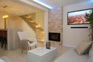 a living room with a couch and a fireplace at LUXIA PRIVATE ESTATE Sauna & Pool x Jacuzzi with Fireplace outdoor lounge in Bihać