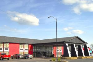 フォートスミスにあるRiver Valley Inn and Suitesの駐車場車を停めた赤黒の建物