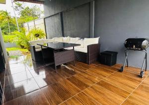 a patio with a table and a grill on the floor at Jarkeyda House in Siquirres