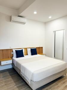 a bedroom with a large white bed with blue pillows at S A L - Village Flats in Caniçal