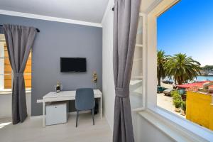 a room with a desk and a window at Rooms Urban design in Zadar
