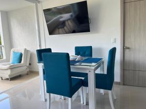 a dining room with a table and blue chairs at Apartasol vacacional in Santa Fe de Antioquia