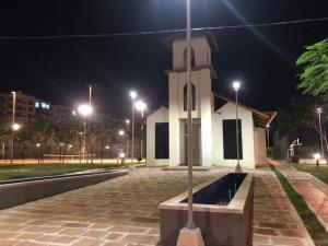 une église la nuit avec un poteau devant dans l'établissement Delicados Pastos, à Ricaurte