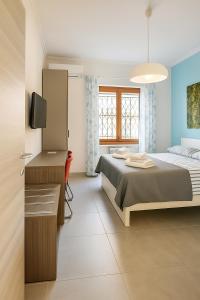 a bedroom with a bed and a desk and a television at Casa Chanel in Rome