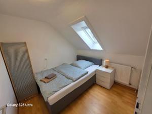 Un dormitorio pequeño con una cama y una ventana. en MaiFerien Harz - Haus Goldstrahl, en Clausthal-Zellerfeld