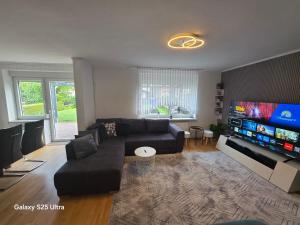 a living room with a couch and a flat screen tv at MaiFerien Harz - Haus Goldstrahl in Clausthal-Zellerfeld