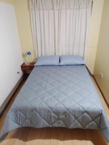 a bed in a bedroom with a large window at El Refugio al Norte del Fin del Mundo A in Río Grande