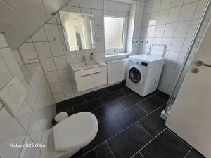 a bathroom with a washing machine and a washer and dryer at MaiFerien Harz - Haus Goldstrahl in Clausthal-Zellerfeld +65 photos
