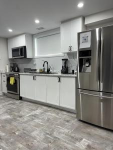 a kitchen with white cabinets and a stainless steel refrigerator at Entire 2 Bedroom Apartment in Kitchener in Kitchener